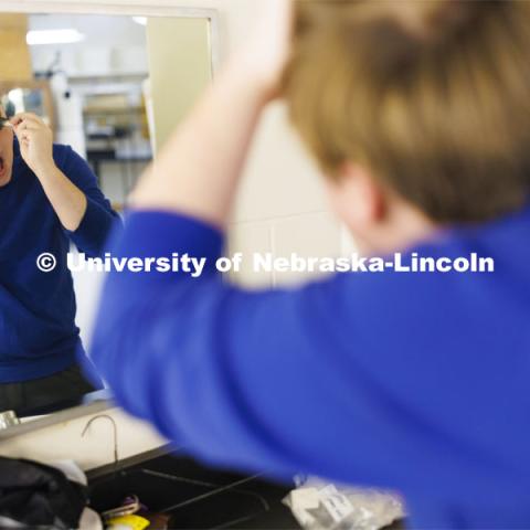 Jackson Wells applies makeup around his eyes as he costumes up to become The Gravedigger. ShakesFear production in the Temple Building. October 21, 2022. Photo by Craig Chandler / University Communication.