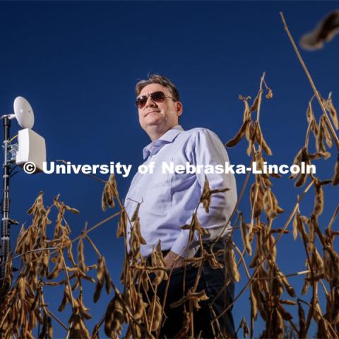 Mehmet Can Vuran lead member of the Field-Nets research team poses in a soybean field on east campus field with a Millimeter-wave (mmWave) radio with phased-array antennas. October 28, 2022. Photo by Craig Chandler / University Communication.
