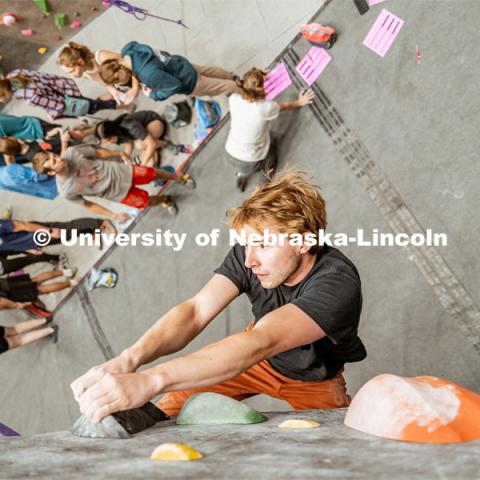 Bryce May, UNL Alumni, climbing a boulder route during the League of Extraordinary Boulderers. League of Extraordinary Boulderers scale the climbing wall at Campus Recreation’s Outdoor Adventure Center. November 3, 2022. Photo by Jonah Tran / University Communication.