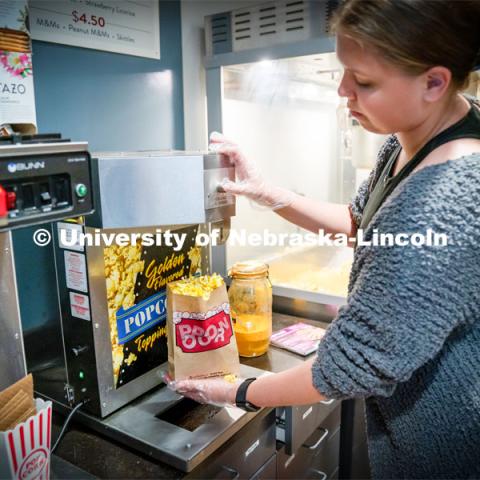 Freshman Emma Georgia helps prepare popcorn for moviegoers at the Ross Theater November 9, 2022. Photo by Dillon Galloway for University Communication