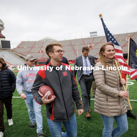 Everett Bloom and Jenalee Wimer, a junior in animal science and Marine Corp Reservist, leave the Memorial Stadium field after Nebraska Athletic Director Trev Alberts presented the game ball that will be part of the Ruck March. November 15, 2022. Photo by Craig Chandler / University Communication.