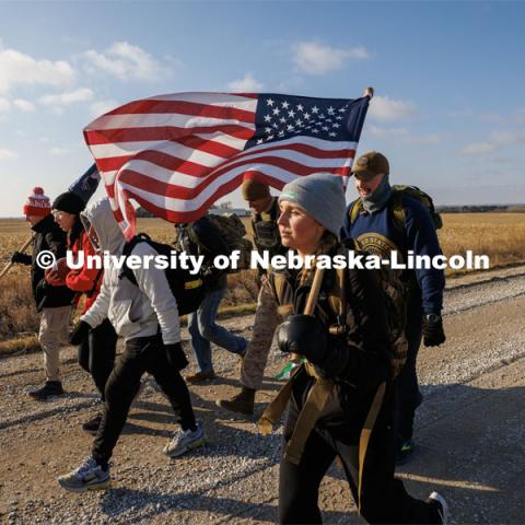 Midshipman Abby Thibodeau and other Ruck Marchers trek along Holdrege Street in rural eastern Lancaster County. Nebraska students and veterans march from Memorial Stadium Wednesday morning. "The Things They Carry" ruck march involving military and veteran students from Iowa and Nebraska. To raise awareness about veteran suicide, through the week, the students walk in 20-mile shifts carrying 20-pound backpacks to commemorate the estimated 20 veterans who die by suicide each day. November 15, 2022. Photo by Craig Chandler / University Communication.