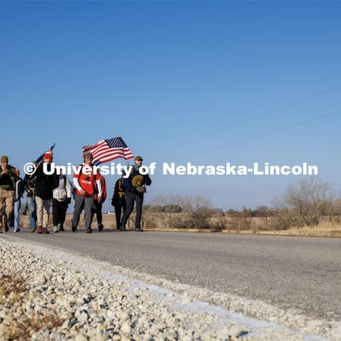 Ruck Marchers walk along Holdrege Street in eastern Lancaster County. Nebraska students and veterans march from Memorial Stadium Wednesday morning. "The Things They Carry" ruck march involving military and veteran students from Iowa and Nebraska. To raise awareness about veteran suicide, through the week, the students walk in 20-mile shifts carrying 20-pound backpacks to commemorate the estimated 20 veterans who die by suicide each day. November 15, 2022. Photo by Craig Chandler / University Communication.