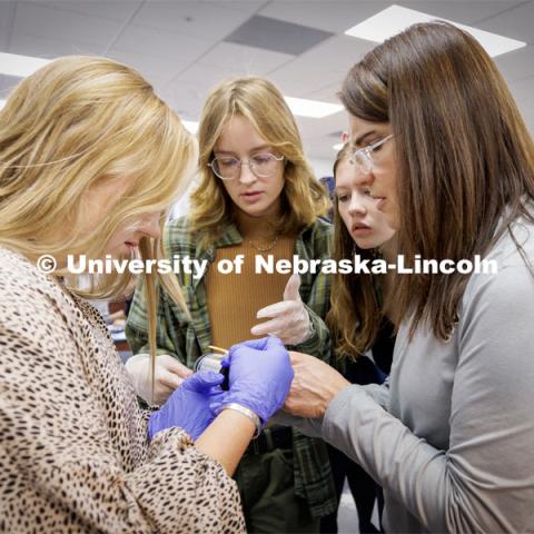 Chelle Gillan helps Taylin Greving, Kit Brooks and Sara Musil compare values on urine samples Friday morning. Chelle Gillan and her Central City class are studying anthropometric differences around the globe. Gillan spent time this summer in Kenya gathering physical data there so students in her Advanced Biology classes could compare and do research. November 18, 2022. Photo by Craig Chandler / University Communication.