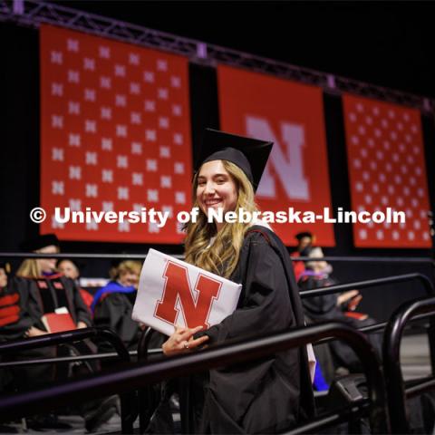 Margarita Shmakova walks offstage after receiving her masters degree in Journalism and Mass Communication. Graduate Commencement in Pinnacle Bank Arena. December 16, 2022. Photo by Craig Chandler / University Communication.