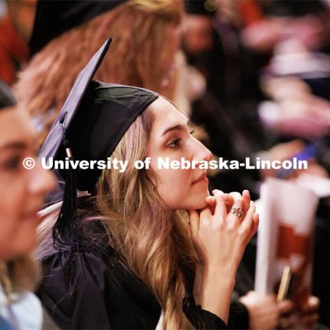 Margarita Shmakova listens to the speakers after receiving her masters degree in Journalism and Mass Communication. Graduate Commencement in Pinnacle Bank Arena. December 16, 2022. Photo by Craig Chandler / University Communication.