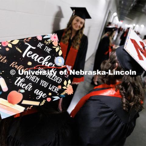 Education graduates Julia Raffel, left, and Alexis Goodenberger wear their decorated mortar boards. Winter Undergraduate Commencement in Pinnacle Bank Arena. December 17, 2022. Photo by Craig Chandler / University Communication.