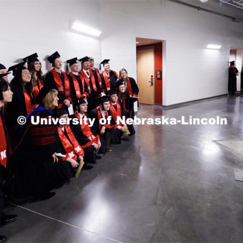 Engineering graduate Zachary Thompson photographs a group of College of Business graduates posing with Dean Kathy Farrell. Winter Undergraduate Commencement in Pinnacle Bank Arena. December 17, 2022. Photo by Craig Chandler / University Communication.