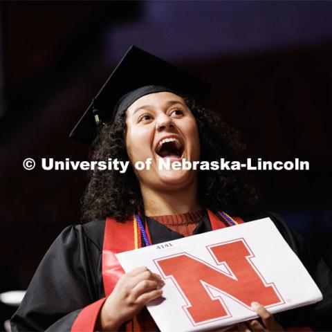 Bella Rodriguez, a graduate in Accounting, smiles for family and friends after receiving her diploma. Winter Undergraduate Commencement in Pinnacle Bank Arena. December 17, 2022. Photo by Craig Chandler / University Communication.