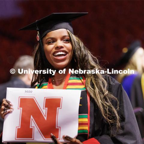 Bouthaina Ibrahim smiles to family and friends after receiving her Journalism and Mass Communication diploma. Winter Undergraduate Commencement in Pinnacle Bank Arena. December 17, 2022. Photo by Craig Chandler / University Communication.