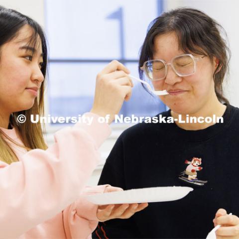 Zhuo Chen wrinkles her nose after smelling a cheese sample held by Baoyue Zhang. Heather Hallen-Adams teaches FDST 492 - Special Topics in Food Science and Technology topic Moldy Meals: Koji and More. January 10, 2023. Photo by Craig Chandler / University Communication.