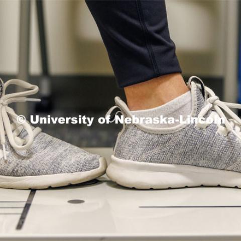 Student Makayla Burchett, a freshman from Harlan, Iowa, performs a Modified Balance Error Scoring System (MBESS) test as she balances on a stress plate in the new concussion clinic. The University Health Center and Nebraska Medicine recently moved its concussion clinic to the Nebraska Performance Lab in the east stadium space. February 1, 2023. Photo by Craig Chandler / University Communication.