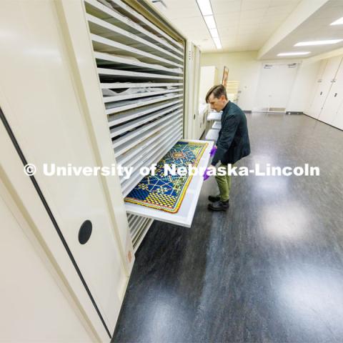 Jamie Swartz, collections assistant, pulls out a soldier’s quilt possibly made in the United States in the period between 1880-1900. Fragile quilts are kept flat in special cabinets of drawers. Quilt Center. February 8, 2023. Photo by Craig Chandler / University Communication.