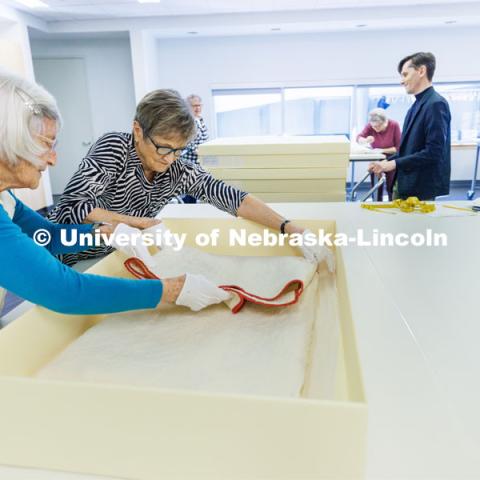 Volunteers Loris Purtzer, left, and Alice Lorenz carefully pack a quilt for storage. Quilt Center. February 8, 2023. Photo by Craig Chandler / University Communication.