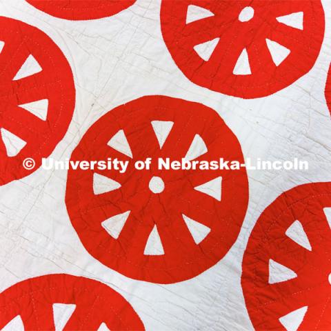 Red wagon wheels decorate the top of a quilt in the Quilt Center. February 8, 2023. Photo by Craig Chandler / University Communication.