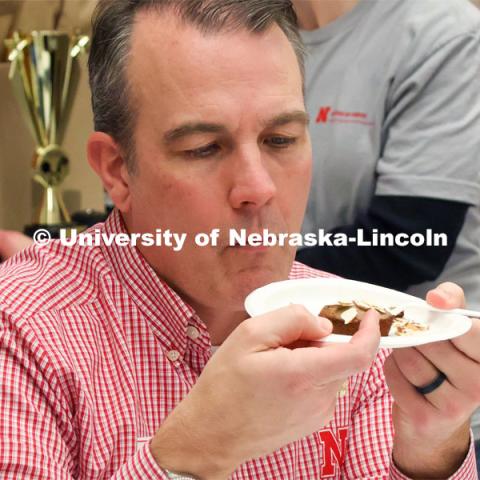 Contest judge Terry Howell with the UNL Food Processing Center gives an entry a close eye as he prepares for a taste. Groups prepared baked goods using flour made from crickets. Battle of the Food Scientists at Nebraska Innovation Campus. February 15, 2023. Photo by Blaney Dreifurst / University Communication.