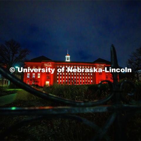 Love Library is lit up in red with gobos projected on the front saying, “Only in Nebraska” and “Glow Big Red”. Glow Big Red. February 15, 2023. Photo by Craig Chandler / University Communication.