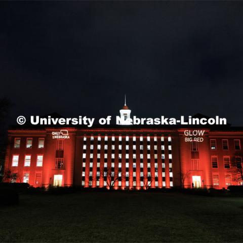 Love Library is lit up in red with gobos projected on the front saying, “Only in Nebraska” and “Glow Big Red”. Glow Big Red. February 15, 2023. Photo by Craig Chandler / University Communication.