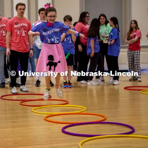 Parker Matzen hops through hulahoops at the 2023 HuskerThon. University of Nebraska–Lincoln students raised $118,208 during the annual HuskerThon on Feb. 25. Also known as Dance Marathon, the event is part of a nationwide fundraiser supporting Children’s Miracle Network Hospitals. The annual event, which launched in 2006, is the largest student philanthropic event on campus. The mission of the event encourages participants to, “dance for those who can’t.” All funds collected by the Huskers benefit the Children’s Hospital and Medical Center in Omaha. February 25, 2023. Photo by Blaney Dreifurst for University Communication.