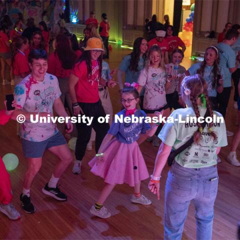 Parker Matzen leads a group of students in a dance during the 70s disco dance party portion of Huskerthon. University of Nebraska–Lincoln students raised $118,208 during the annual HuskerThon on Feb. 25. Also known as Dance Marathon, the event is part of a nationwide fundraiser supporting Children’s Miracle Network Hospitals. The annual event, which launched in 2006, is the largest student philanthropic event on campus. The mission of the event encourages participants to, “dance for those who can’t.” All funds collected by the Huskers benefit the Children’s Hospital and Medical Center in Omaha. February 25, 2023. Photo by Blaney Dreifurst for University Communication.