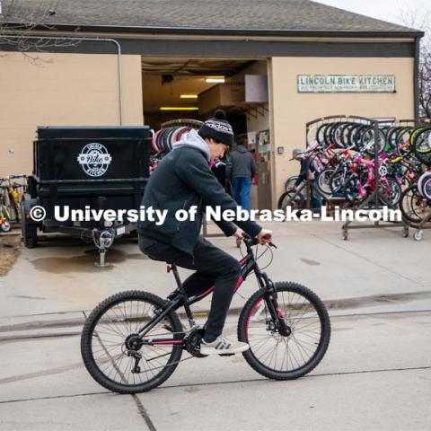 Jacob Dalton test rides a bike outside the Lincoln Bike Kitchen after making a repair. Lincoln Bike Kitchen organizers have set an annual goal of giving away 1,000 bikes to area youth and adults in need. The Bike Kitchen is among a number of local organizations that the College of Engineering works with to offer service learning opportunities to its students. March 9, 2023. Photo by Dillon Galloway for University Communication.