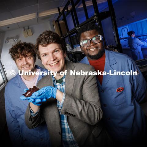 Nebraska chemists James Checco (center), Baba Yussif (right) and Cole Blasing have found that a natural, ultra-minor alteration to a molecule can dictate which neuron receptors a neurotransmitter will activate. The team discovered the phenomenon in a species of sea slug being held by Checco, though the findings should apply to a range of animals — potentially even humans. March 9, 2023. Photo by Craig Chandler / University Communication.