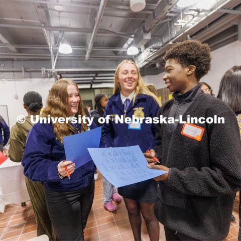 Jacie Bonneau and Kirsten Frey from Pender FFA talk with Ahmed Babiker from Lincoln Northeast FFA as they play a game of bingo to learn about each other. FFA pen pals from urban and rural schools meet face-to-face during the FFA state convention. March 29, 2023. Photo by Craig Chandler / University Communication.