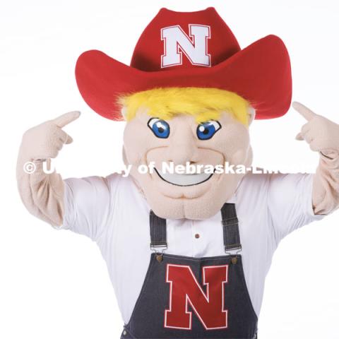 Studio portrait of Herbie pointing to the N on his hat. New Herbie photoshoot. April 7, 2023. Photo by Craig Chandler / University Communication.