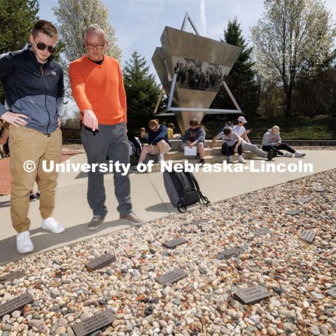 Gerald Steinacher, professor of history, tells Nick Scholtes, a senior from Lincoln, the stories behind the memorial bricks. Each brick was engraved for a person murdered in the Holocaust with ties to Nebraska. History of the Holocaust course students visit the Holocaust memorial in Lincoln’s Wyuka Cemetery. April 18, 2023. Photo by Craig Chandler / University Communication.