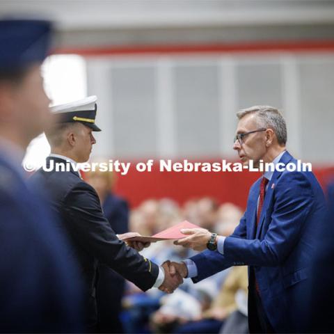 Chancellor Ronnie Green presents the Chancellor’s Academic Excellence Award to Midshipman Colin Harju. Six ROTC members were given the award at the ROTC Joint Service Chancellor’s Review in Cook Pavilion.  April 27, 2023. Photo by Craig Chandler / University Communication.
