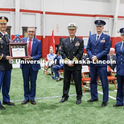 Chancellor Ronnie Green accepts a shadowbox from Lieutenant Colonel Mark Peer. left, along with Captain Orlando Bowman, Lieutenant Colonel Philip Garito and Colonel (Ret.) Joe Brownell. ROTC Joint Service Chancellor’s Review in Cook Pavilion. April 27, 2023. Photo by Craig Chandler / University Communication.