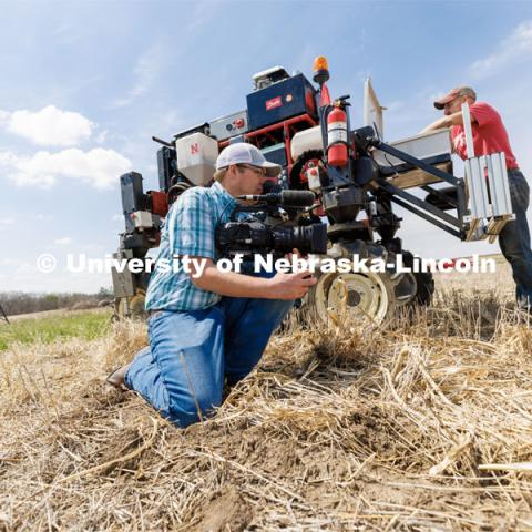 Bryce Doeschot, Market Journal and IANR Media, films the planting. The self-driving robotic planter based on Santosh Pitla’s tractor platform works its way through a field at the Rogers Memorial Farm east of Lincoln. April 27, 2023. Photo by Craig Chandler / University Communication.