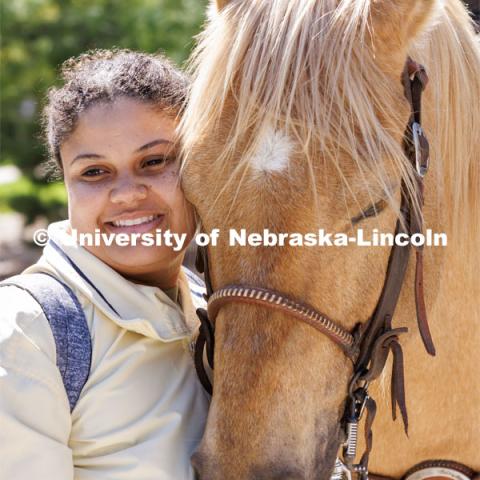 Rachel Freeman, a junior from Des Moines, poses so her friend can take her photo with a horse. Students in Rob Simon’s capstone marketing course held a promotional event for the UNL rodeo on the west side of the Union on City Campus. The class developed a marketing strategy for the Rodeo Club to help promote their upcoming rodeo. Seven horses and multiple club members were on city campus for students to meet, get close to and have their photos taken. May 1, 2023. Photo by Craig Chandler / University Communication.