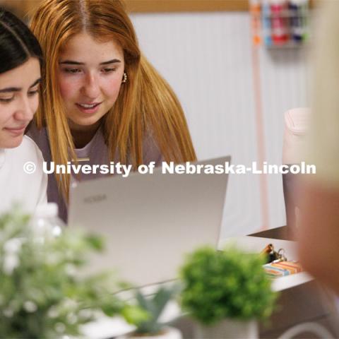 Valeria Uribe and Hannah Kate Kinney look over their project at the Jacht Ad Agency. May 10, 2023. Photo by Craig Chandler / University Communication.