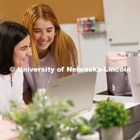 Valeria Uribe and Hannah Kate Kinney look over their project at the Jacht Ad Agency. May 10, 2023. Photo by Craig Chandler / University Communication.