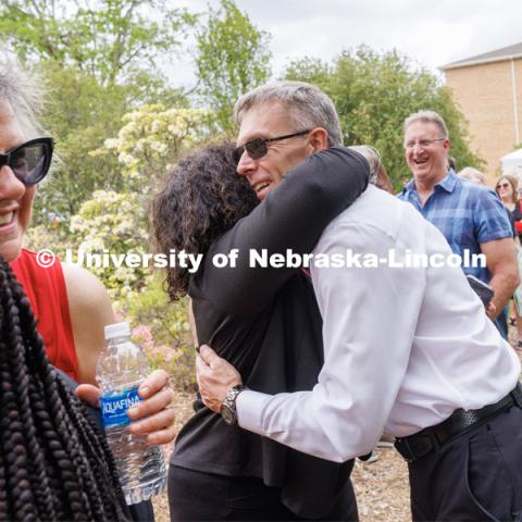 Ronnie Green hugs Charlie Foster as Jane Green hugs Reshell Ray in the reception line. Ronnie and Jane Green had an open house Thursday at the Maxwell Arboretum on East Campus. May 11, 2023. Photo by Craig Chandler / University Communication.