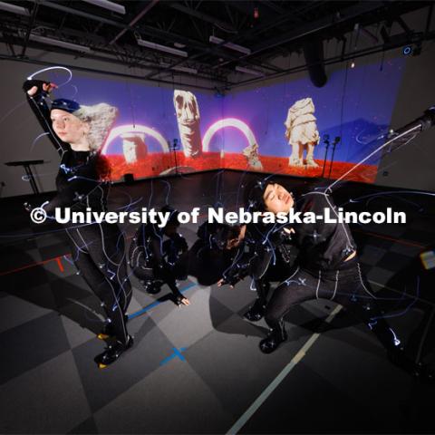 Students work in the Johnny Carson EMA MoCap (motion capture) lab wearing MoCap suits. The suits with their infrared sensors (round dots velcroed to the suit) allow a ring of cameras to turn their motion into animated characters on screen. May 17, 2023. Photo by Craig Chandler / University Communication.