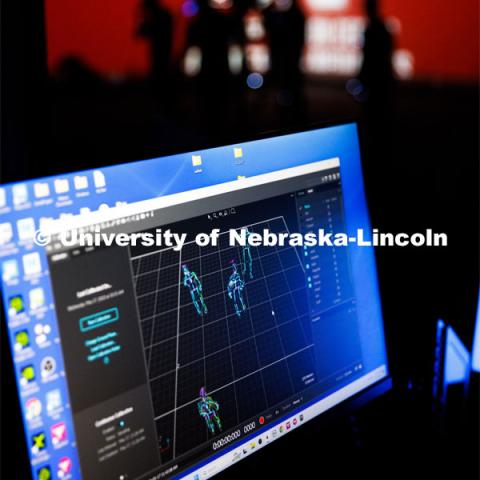 Students work in the Johnny Carson EMA MoCap (motion capture) lab wearing MoCap suits. The suits with their infrared sensors (round dots velcroed to the suit) allow a ring of cameras to turn their motion into animated characters on screen. May 17, 2023. Photo by Craig Chandler / University Communication.