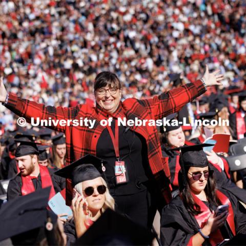 Annette Wetzel, Executive Director, Special Events and Protocol, smiles for a photo with her arms outstretched in a sea of Husker grads before undergraduate commencement. Undergraduate commencement at Memorial Stadium. May 20, 2023. Photo by Craig Chandler / University Communication.