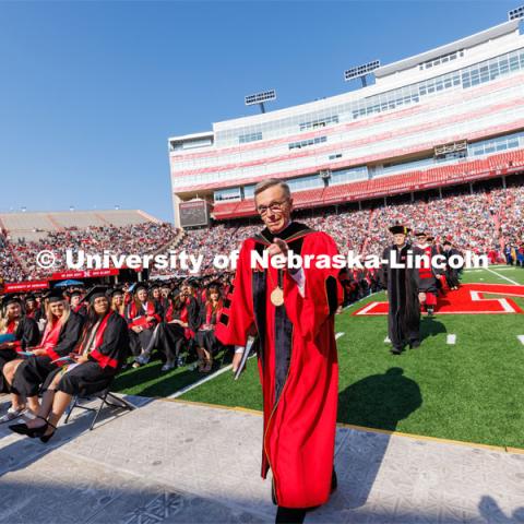 Chancellor Ronnie Green points to the camera as he walks down the aisle to give his last commencement speech as Chancellor of the University of Nebraska. Undergraduate commencement at Memorial Stadium. May 20, 2023. Photo by Craig Chandler / University Communication.
