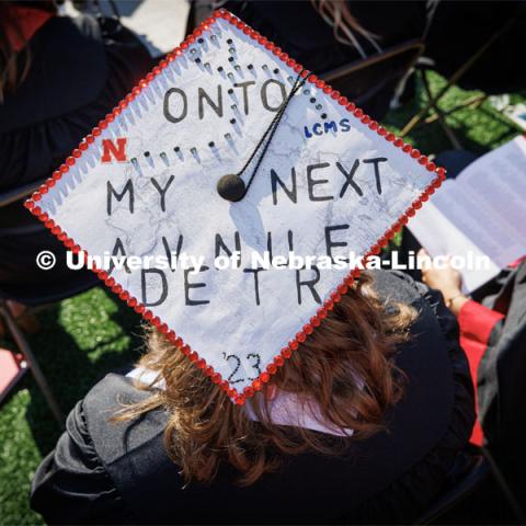A decorated cap says, "Onto my next adventure". Undergraduate commencement at Memorial Stadium. May 20, 2023. Photo by Craig Chandler / University Communication.