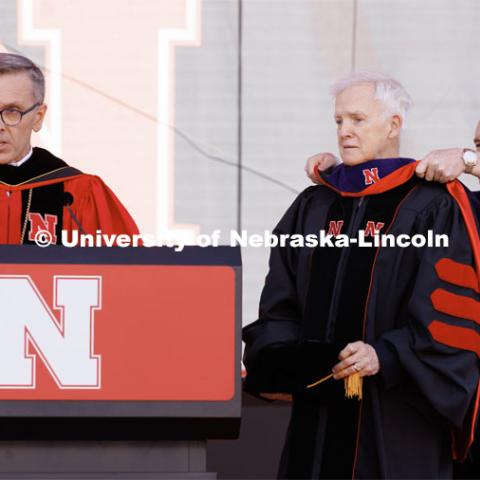 Former Senator and Nebraska Governor Bob Kerrey receives an honorary Doctor of Law degree at commencement. He is hooded by Board of Regent Tim Claire. Undergraduate commencement at Memorial Stadium. May 20, 2023. Photo by Craig Chandler / University Communication.