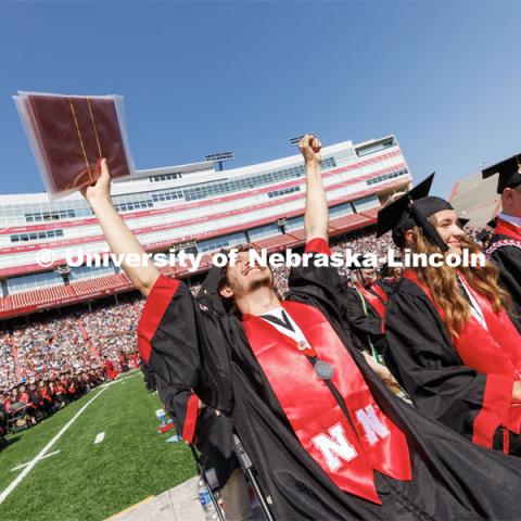 Stephen Yaghmour, a Chancellor Scholar who finished at UNL with a 4.0 GPA, celebrates after receiving his diplomas. Undergraduate commencement at Memorial Stadium. May 20, 2023. Photo by Craig Chandler / University Communication.
