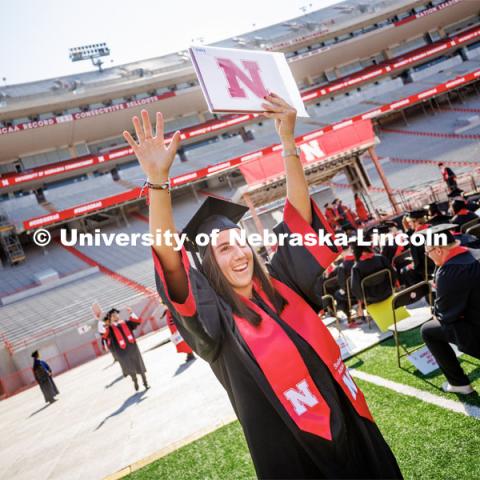 Isabel Adrover Gallego waves to family and friends after receiving her diploma. Undergraduate commencement at Memorial Stadium. May 20, 2023. Photo by Craig Chandler / University Communication.