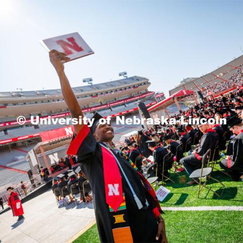 Seth Caines waves to family and friends after receiving his engineering diploma. Undergraduate commencement at Memorial Stadium. May 20, 2023. Photo by Craig Chandler / University Communication.
