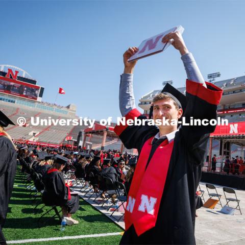 Chase Wolgamott waves to family and friends after receiving his College of Business degree. Undergraduate commencement at Memorial Stadium. May 20, 2023. Photo by Craig Chandler / University Communication.