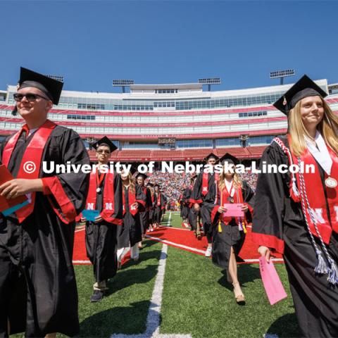 Arts and Science graduates walk toward the stage. Undergraduate commencement at Memorial Stadium. May 20, 2023. Photo by Craig Chandler / University Communication.




