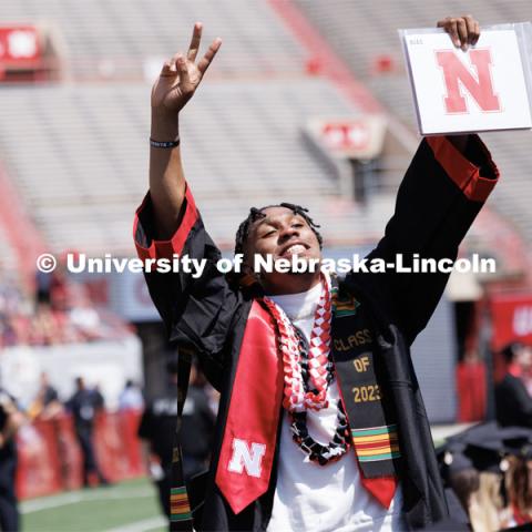 Javin Wright waves to family and friends after receiving his degree in sports media and communication. Undergraduate commencement at Memorial Stadium. May 20, 2023. Photo by Craig Chandler / University Communication.