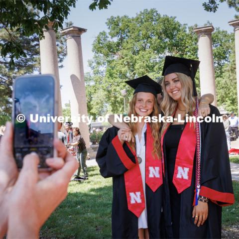 Jayme Soderbeck, left, and Adeline Burger pose with a friend as family members take photos following commencement. Undergraduate commencement at Memorial Stadium. May 20, 2023. Photo by Craig Chandler / University Communication.