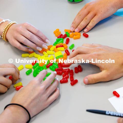 Jill Trucke, the accounting professor, leads her group through an accounting exercise for a fictional fruit stand.  The role of the fruit is played by multi-colored candies. The students must inventory, purchase new fruit, sell fruit and calculate sales and profits. College of Business high school pre-college program called Discover Accounting. June 2, 2023. Photo by Craig Chandler / University Communication.